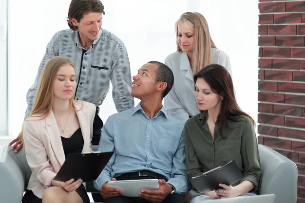 Business woman and her business team discussing the data with a tablet computer