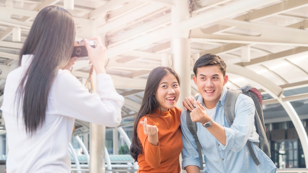 business woman hold camera to shoot the traveler couple people at urban city