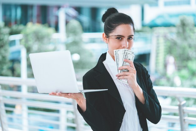 Donna di affari che tiene computer portatile in bianco