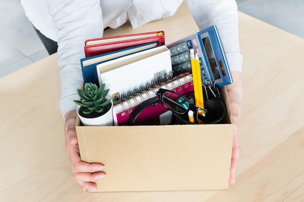 Business woman holding cardboard box with personal company belongings