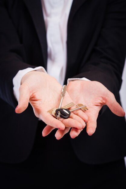 Business woman holding keys over white background