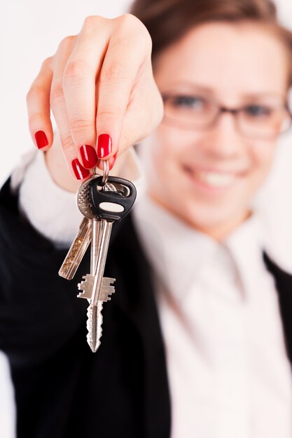 Business woman holding keys over white background