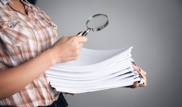 Photo business woman holding magnifying glass and documents