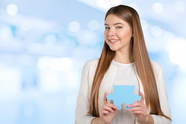 Business woman holding puzzle piece