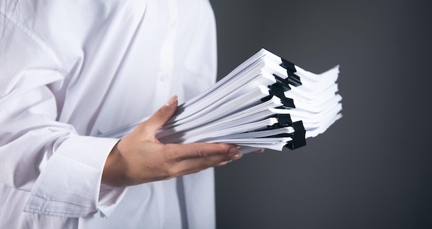 The business woman holding stack of files.