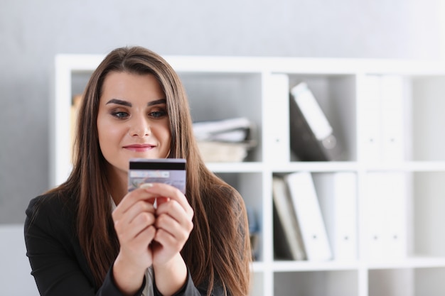 Фото Деловая женщина в офисе держит пластиковую кредитную дебетовую карту в руке