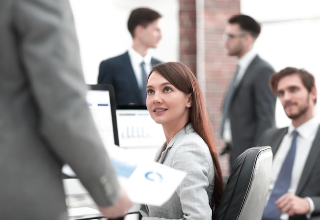 Business woman is analyzing financial graphs on the computer