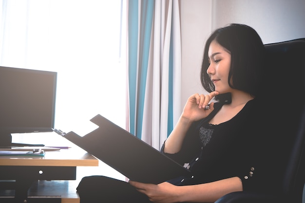 Business woman is reading business report in office