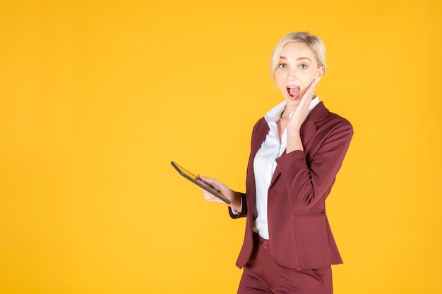 Business woman is surprising  in studio yellow background 