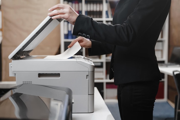 Business woman is using the printer to scanning and printing document