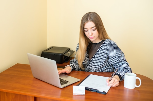 Business woman is writing on a document