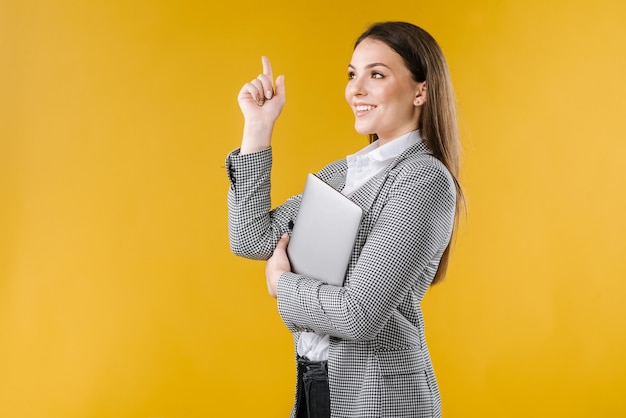 Business woman in jacket pointing finger up, idea concept