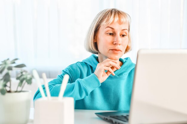 Business woman listening educational lecture on computer\
watching webinar studying on online courses writing notes in paper\
copybook elearning concept