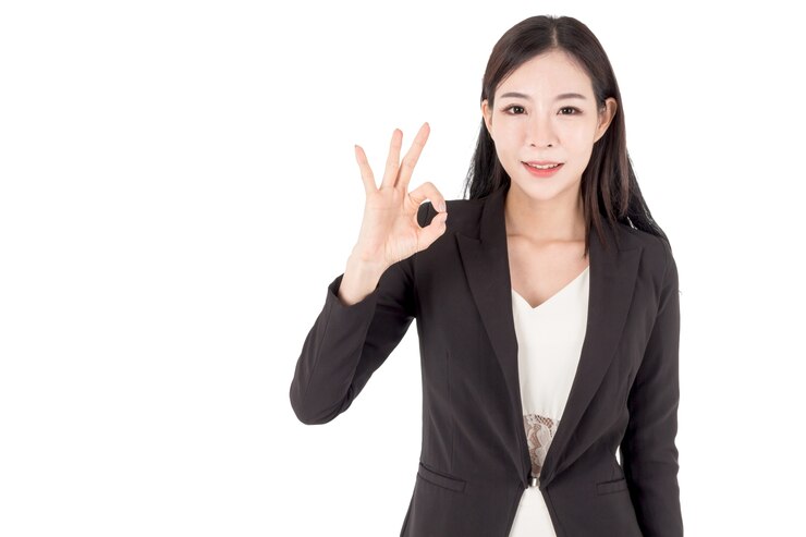 ビジネスの女性は、OKのサインを白い背景に作成