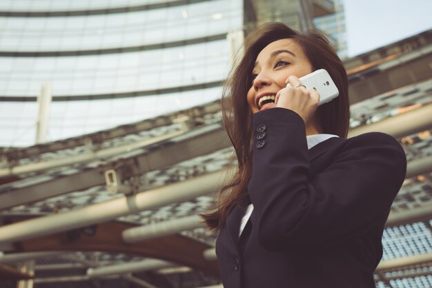 Donna di affari che fa una telefonata fuori dell'ufficio