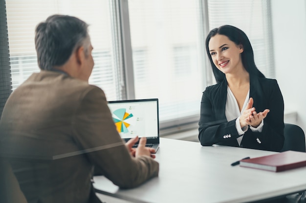 The business woman and a man talking at the office table