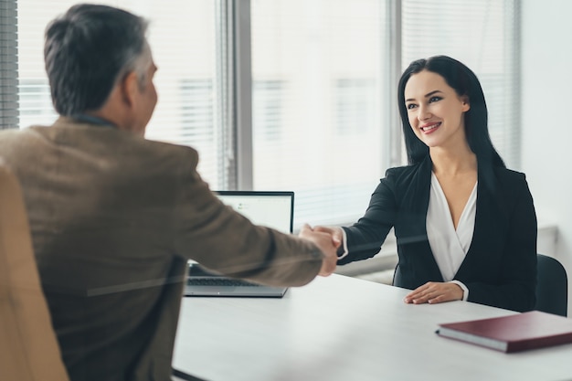 La donna d'affari e un uomo che parlano al tavolo dell'ufficio