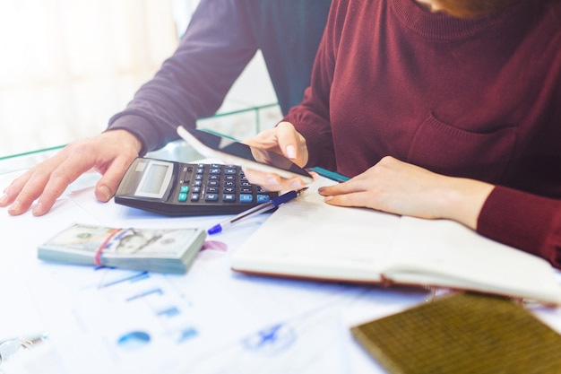 Business woman and man works at home, remote work at home, with laptop and notepad, takes notes on the phone, counts on a calculator