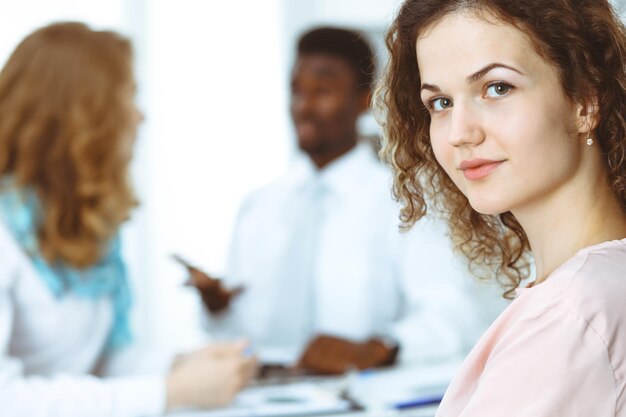 Photo business woman at meeting in office, colored in white. multi ethnic business people group.