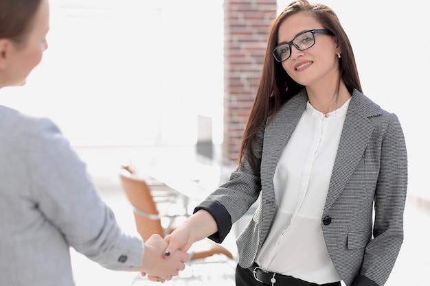 Business woman meets the client with a handshake