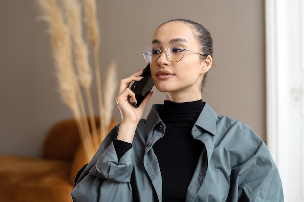 Business woman in the office glasses on her face talking phone