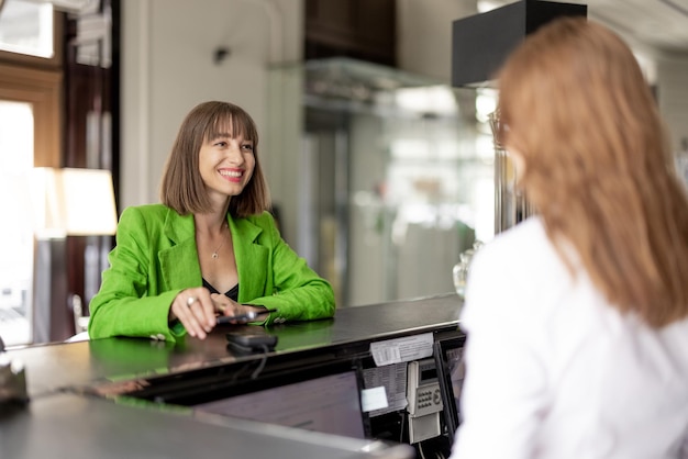 Photo business woman pays at the hotel reception