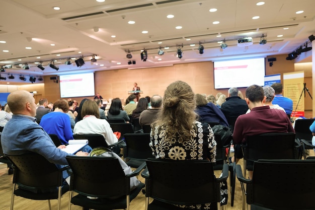 Donna d'affari e persone che ascoltano il concetto di affari della conferenza