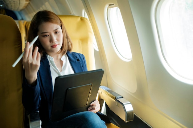 Photo business woman in a plane and works on laptop