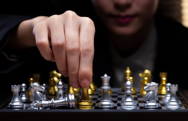 Business woman play chess with close up hand leader use\
strategy game to challenge competitor with intelligence leadership\
to move king to victory with management team idea fight copy\
space