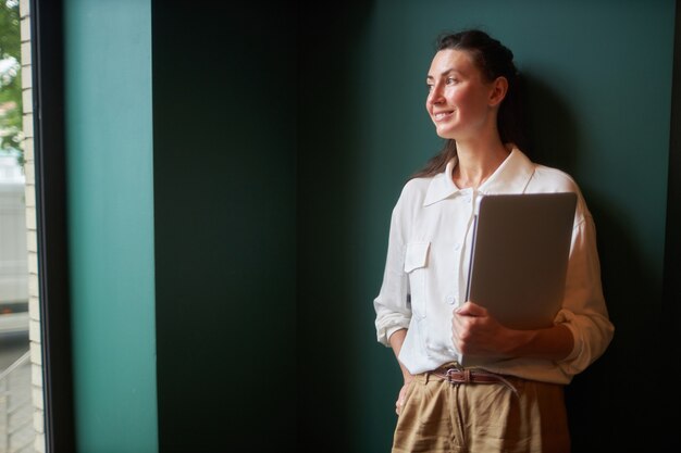 Business woman portrait with laptop. She is working and relaxing at a cafe drinking coffee