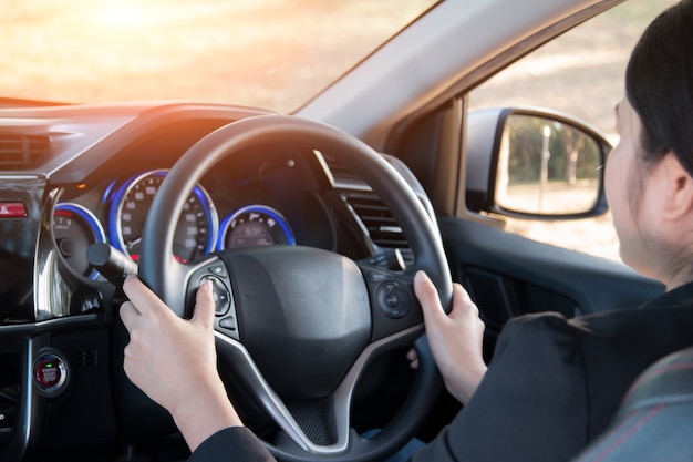 La donna di affari spinge un bottone in automobile moderna.