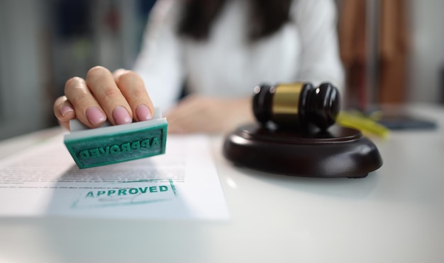 Business woman puts an approved seal on a closeup of document