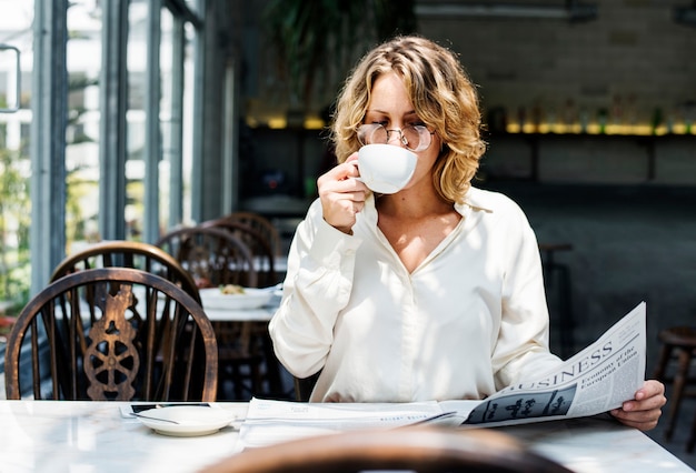 Business woman reading newspaper in the morning