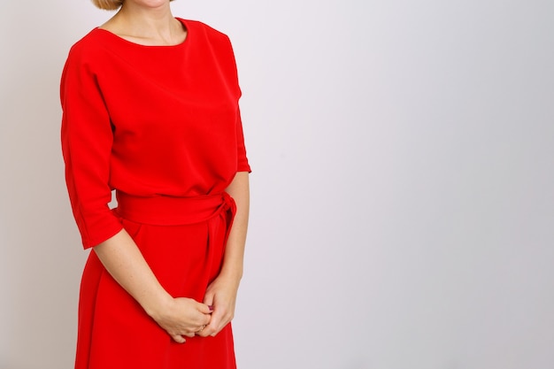 Business woman in a red dress on a light surface