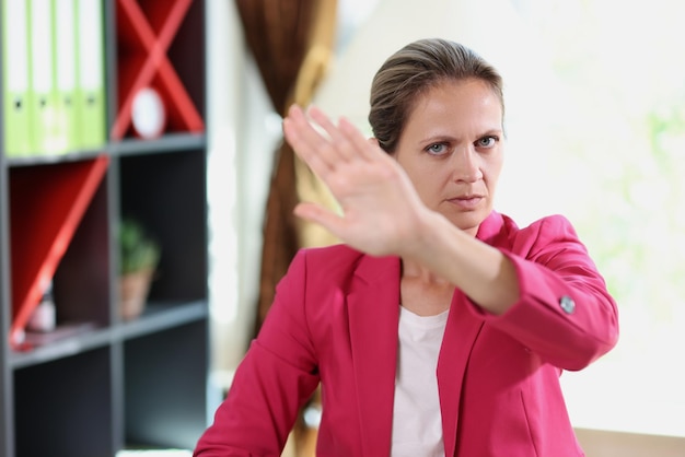 Business woman refuses offers while sitting at office table