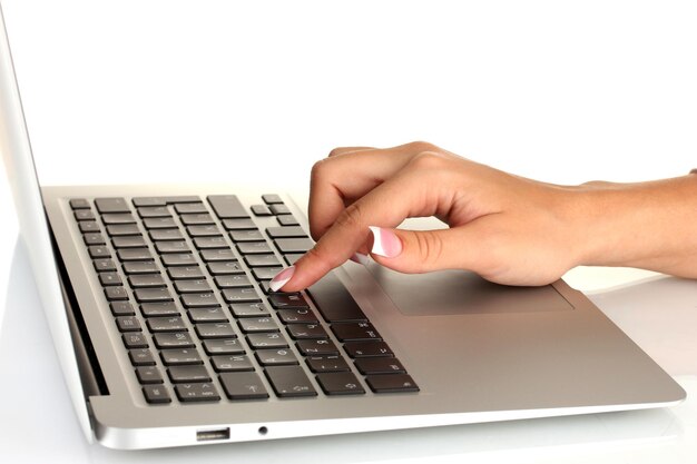 Business woman's hands typing on laptop computer on white background closeup