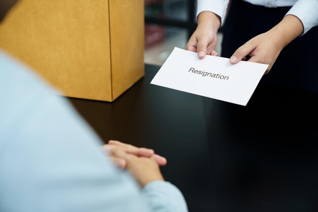 Foto donna d'affari che invia una lettera di dimissioni al capo e holding stuff dimettersi deprimere o trasportare una scatola di cartone dalla scrivania in ufficio