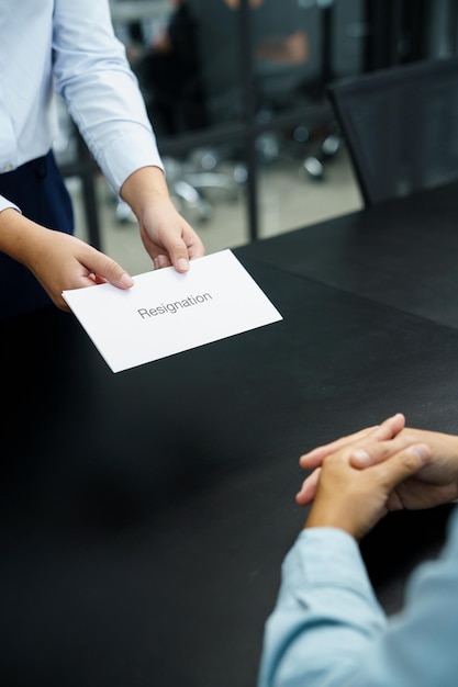 Business woman sending resignation letter to boss and Holding Stuff Resign Depress or carrying cardboard box by desk in office