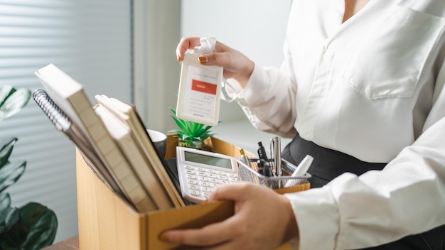 Business woman sending resignation letter and packing Stuff Resign Depress or carrying business cardboard box by desk in office Change of job or fired from company