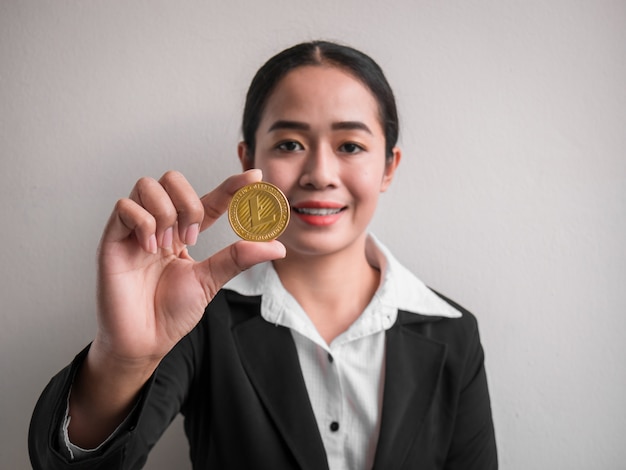 Business woman showing gold litecoin.