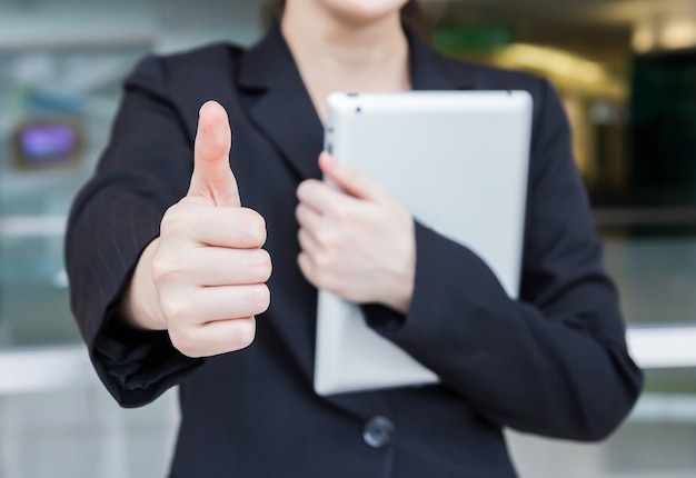 Photo business woman showing thumbs up and holding digital tablet