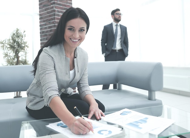 Business woman signs documents in a modern office photo with copy space