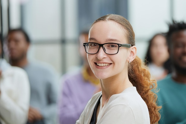 Business woman sitting on a chair with her staff in the background