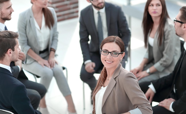 Business woman sitting in a circle with a business team