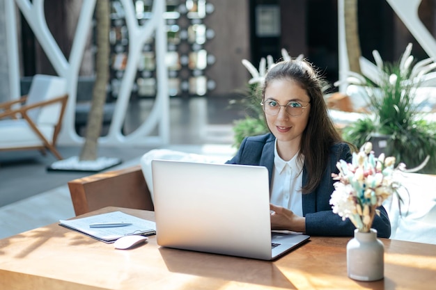 Donna di affari che si siede ad un computer portatile in un caffè