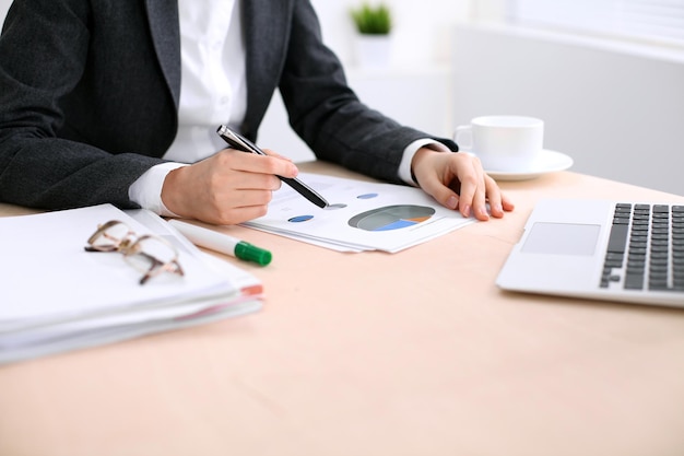 Business woman sitting at the table and examines the financial results.