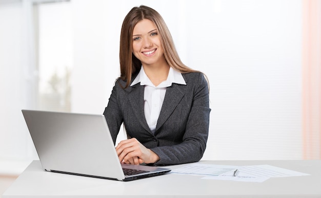 Business woman sitting at white table with hand drawn graph charts