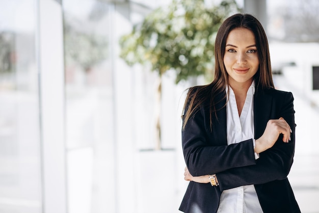 Donna d'affari in piedi in ufficio in abbigliamento formale