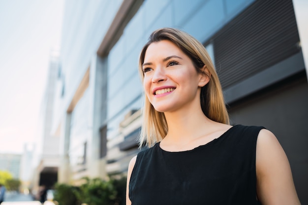 Business woman standing outside office buildings.