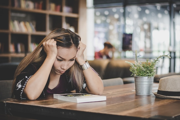 Business woman stress hand on head while sitting at cafe.